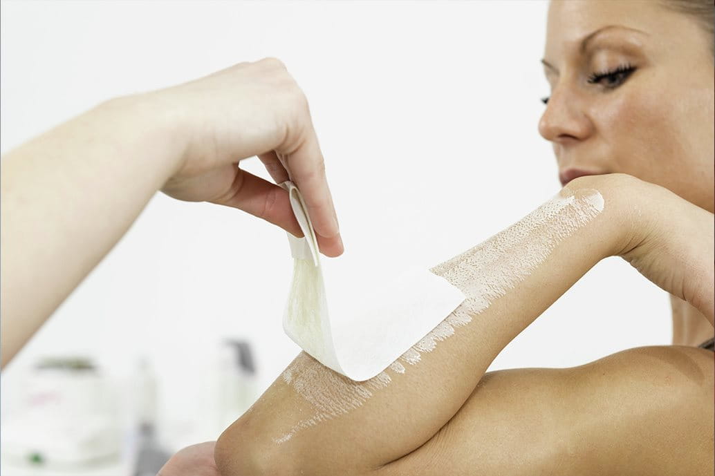 Donna che esegue la ceretta sulle braccia.