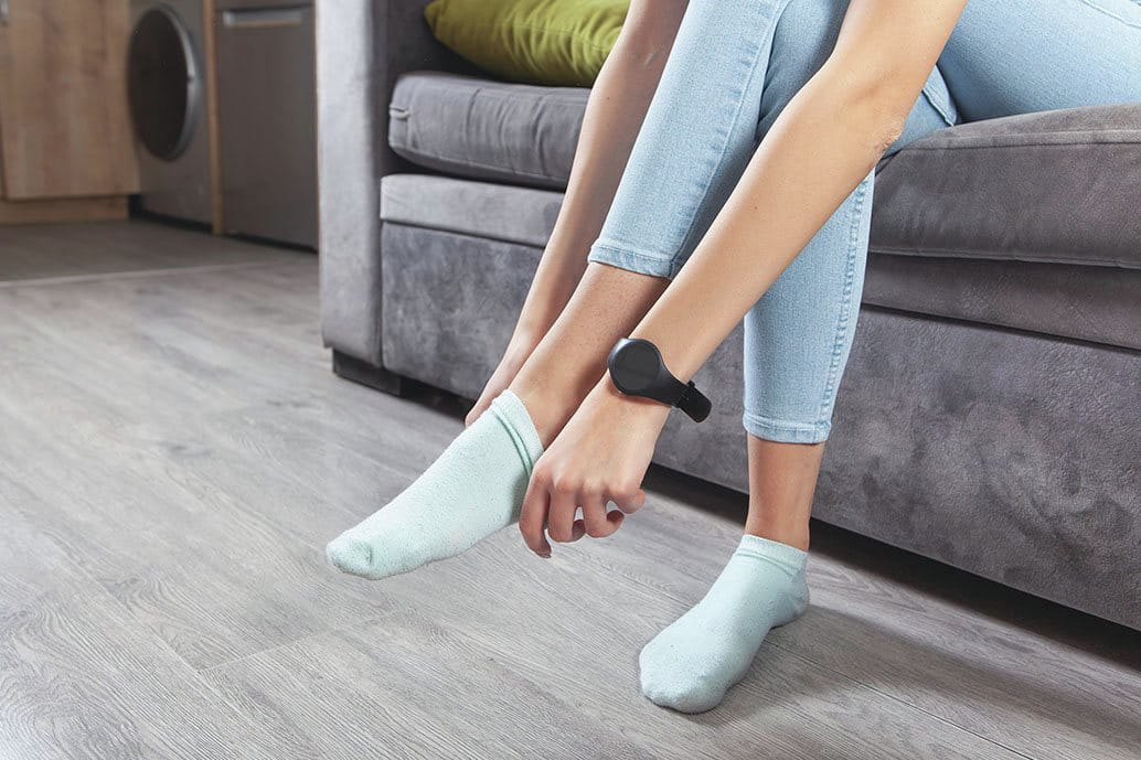  Persona seduta sul divano mentre sostituisce i calzini in cotone