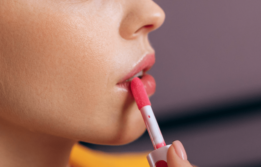 Vrouw brengt met een penseel lipkleur aan.