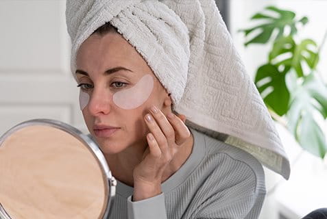 Frau betrachtet geschwollene Augenlider