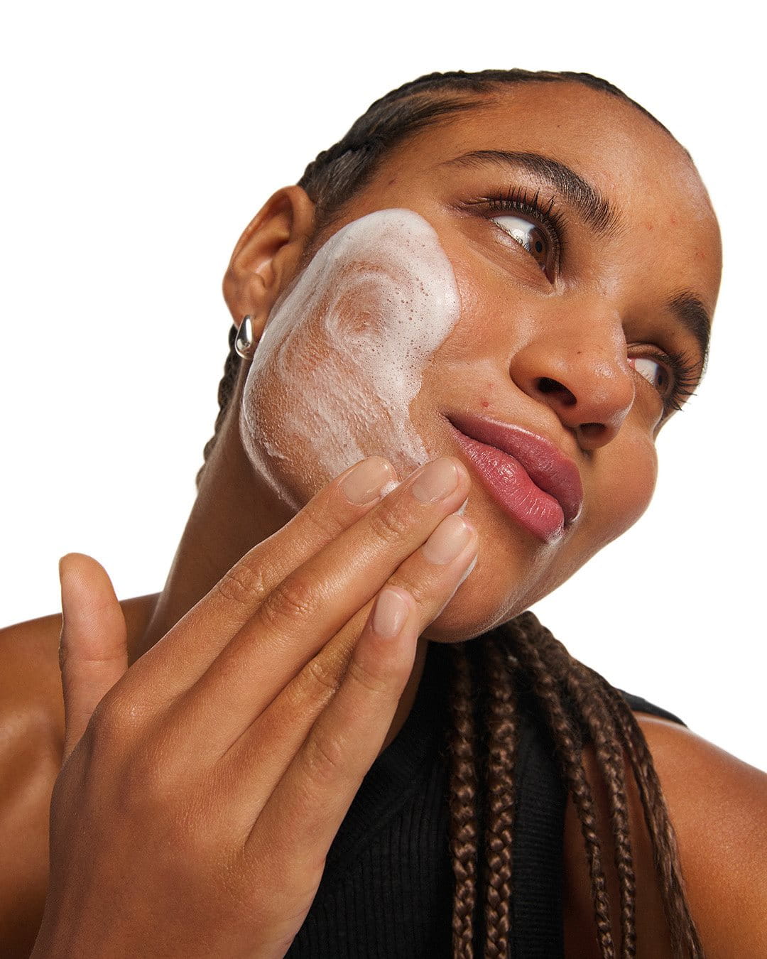 Close-up of a woman applying a  or face wash.