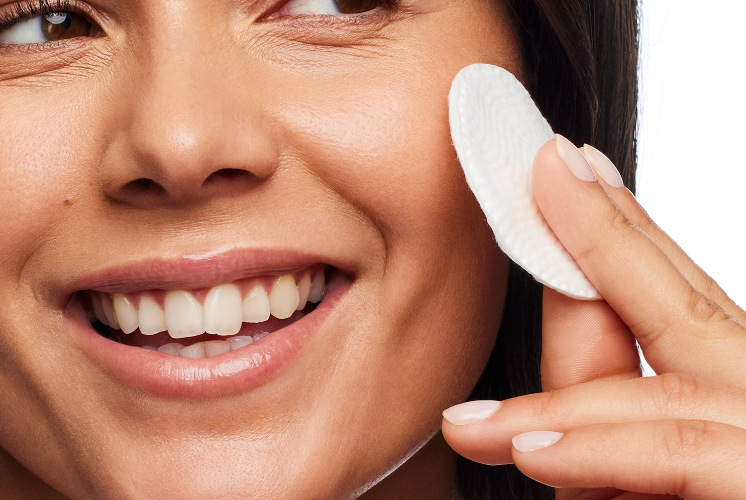 Woman using a cotton pad to cleanse her cheek