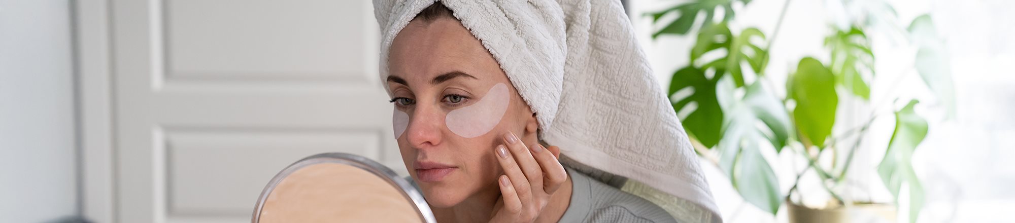 Frau betrachtet sich in Spiegel