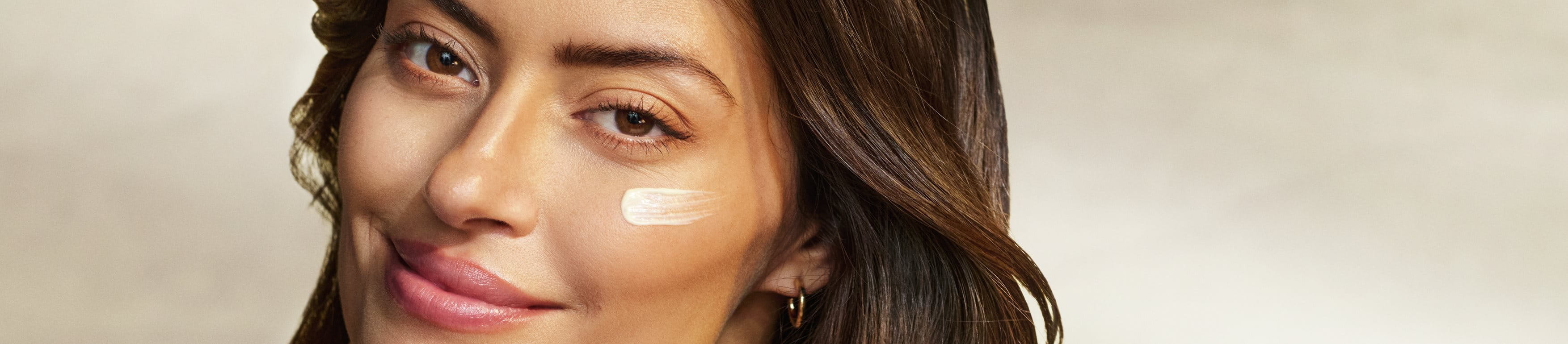 a woman using tinted sunscreen on her face