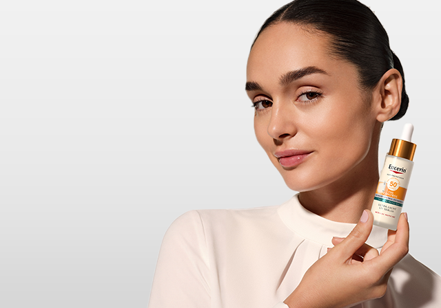 O femeie ținând în mână Serumul pentru față Eucerin cu SPF 50+ Oil Control