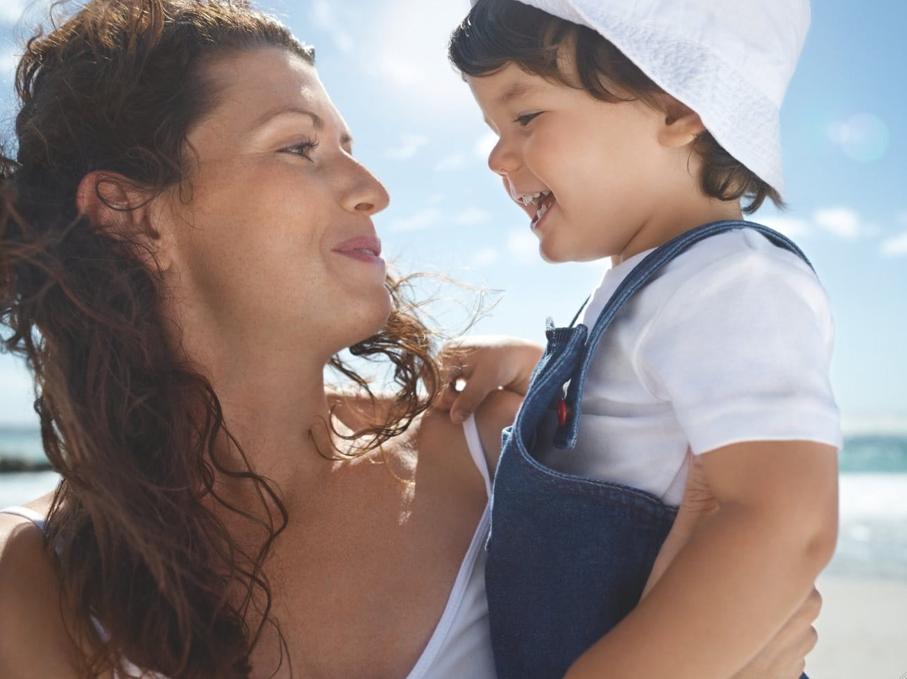 Woman holding her baby on the beach