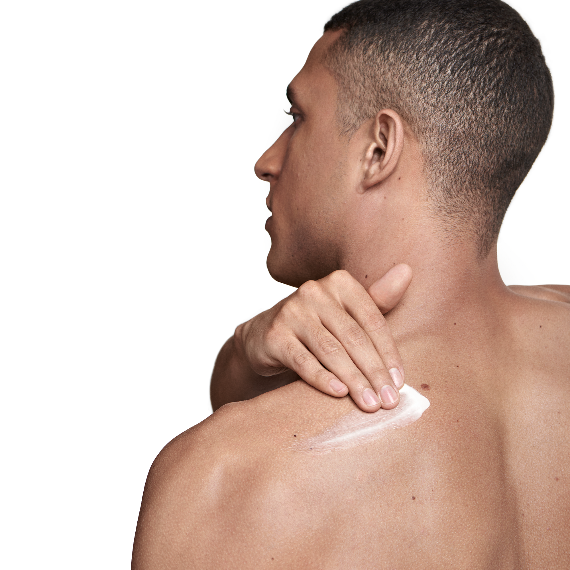 Back view of a man applying cream to his upper back and shoulder.