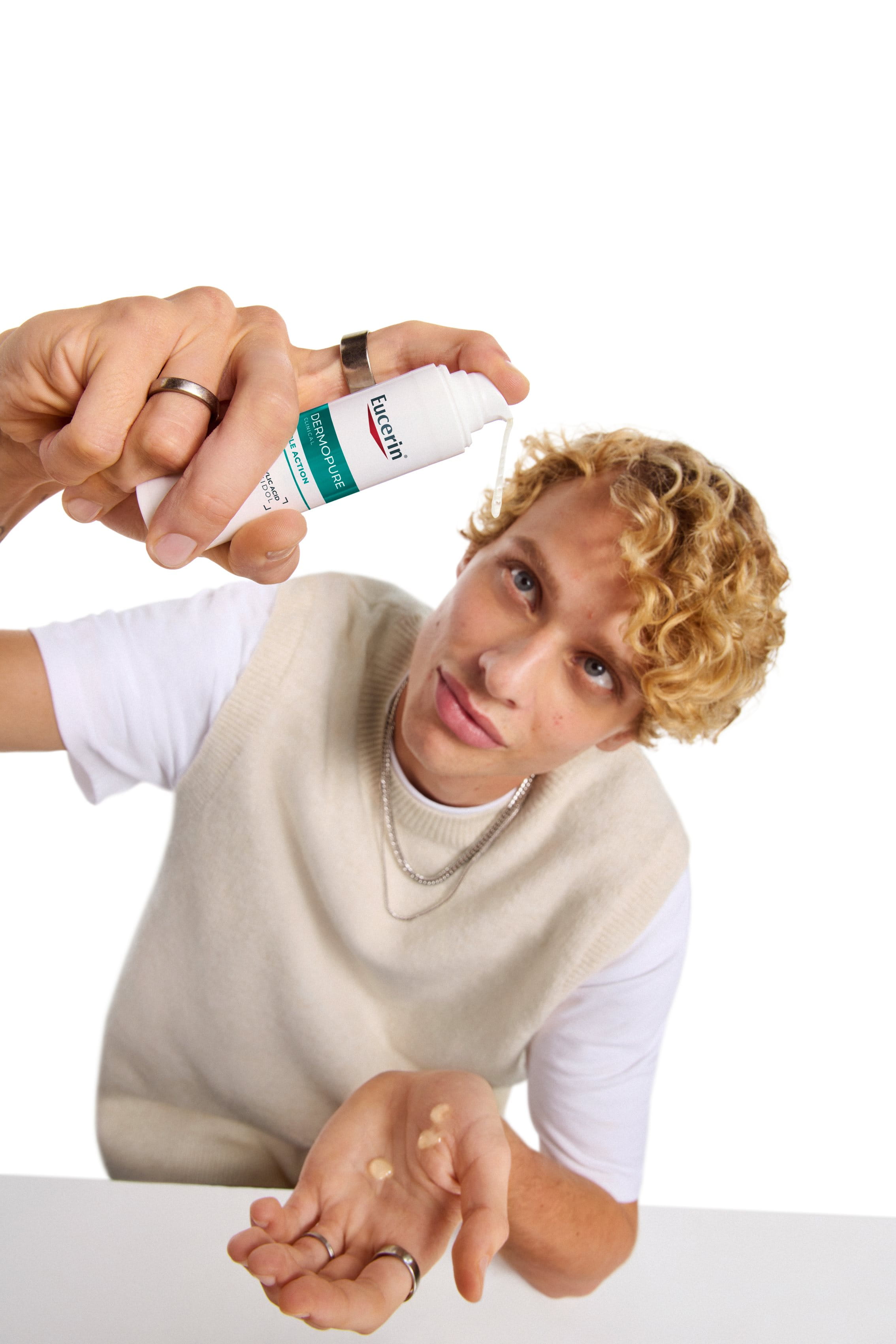 En man som använder Eucerin DERMOPURE Triple Action för hud som lätt får blemmor 