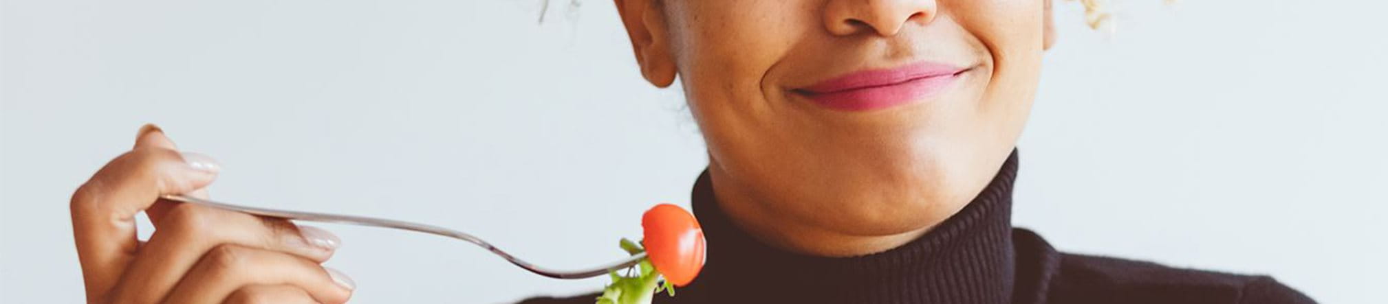 Vrouw met eten op een vork