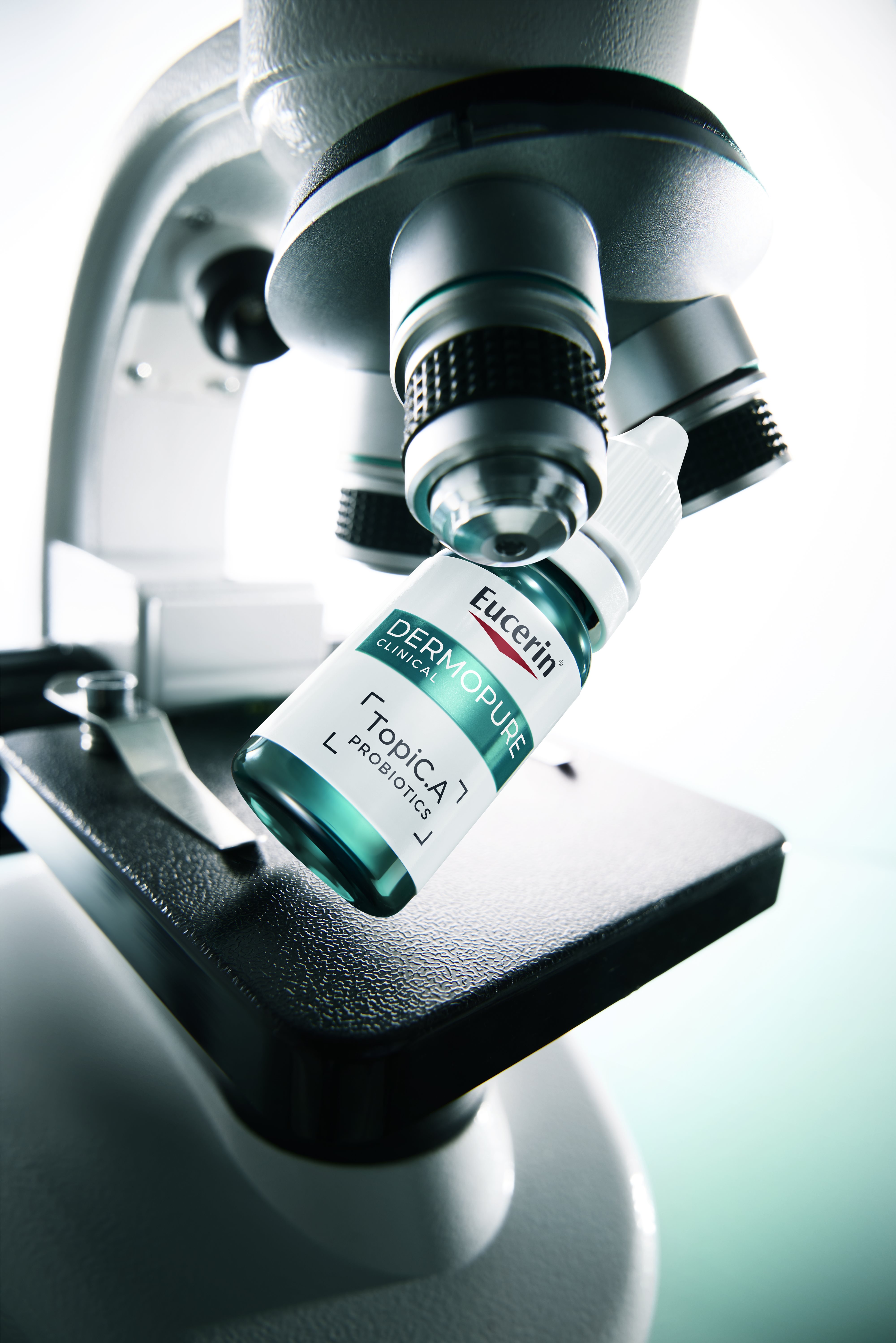 Bottle of Eucerin Probiom8 TopiC.A beside a microscope