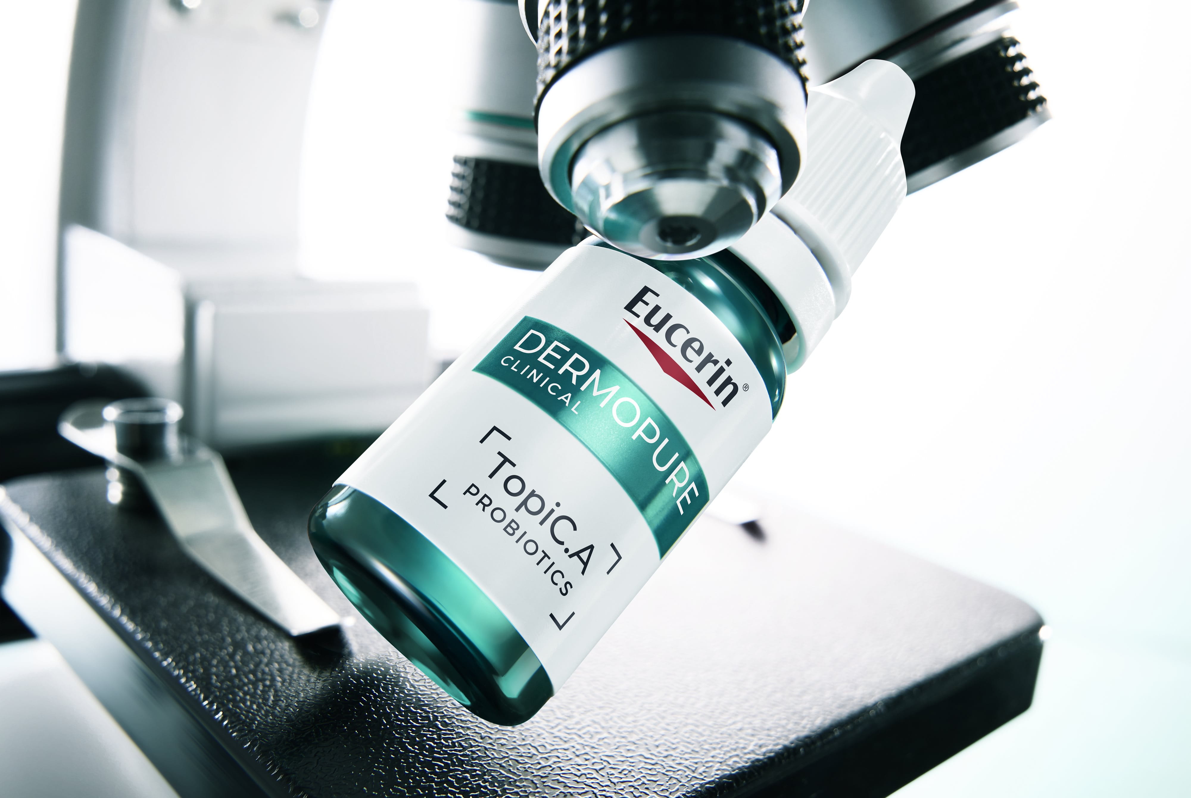 Bottle of Eucerin Probiom8 TopiC.A beside a microscope