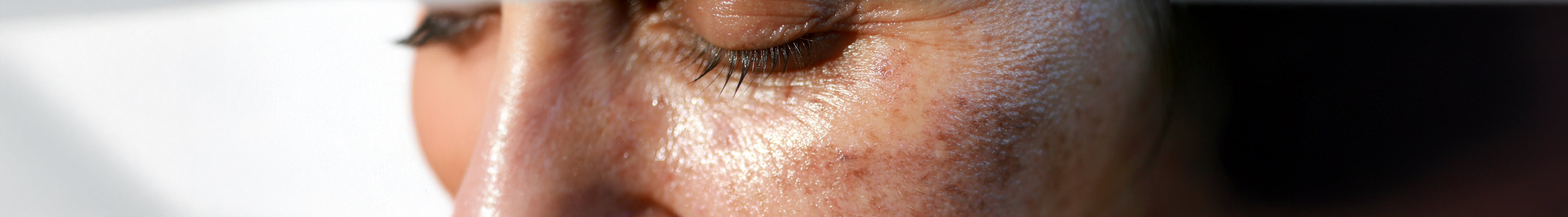 Frau cremt sich das Gesicht ein