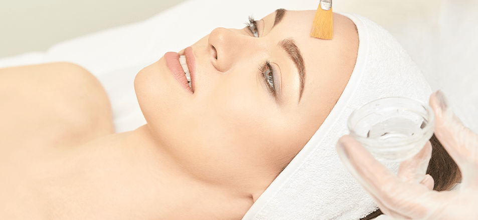 A chemical peel being applied on a woman’s face.