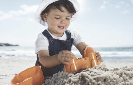 bebé a brincar na areia da praia