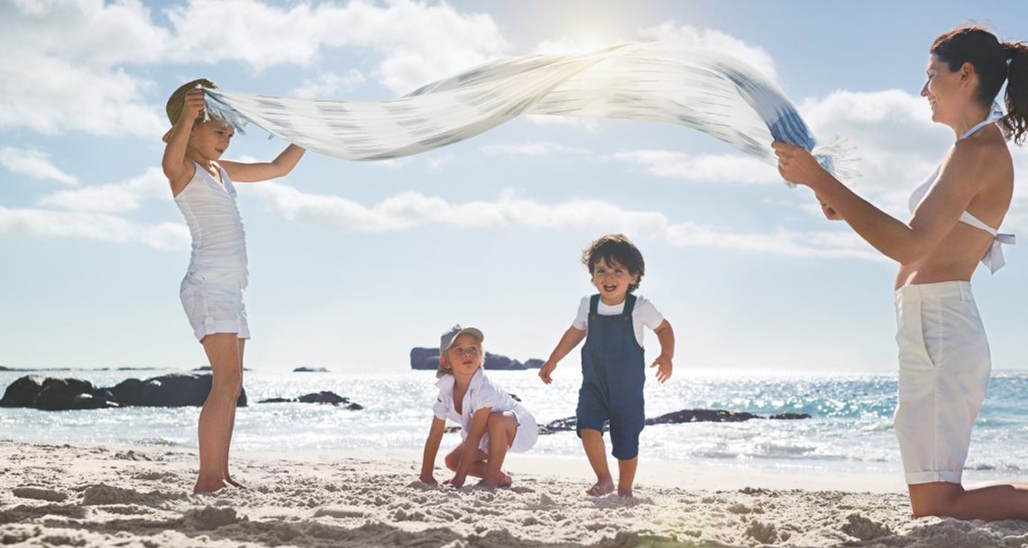 A woman with her three kids enjoying their private time at beach