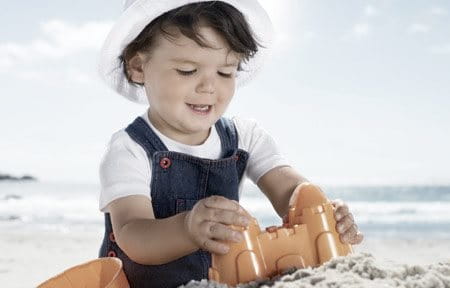 dijete radi kule od pijeska na plaži