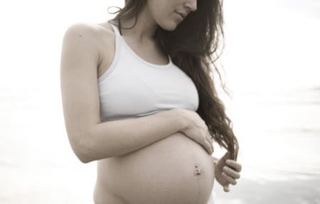 Pregnant woman with one hand on her belly