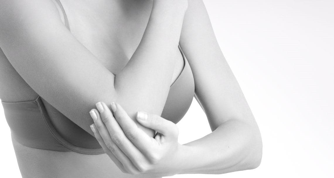 Woman wearing a bra touching her elbow