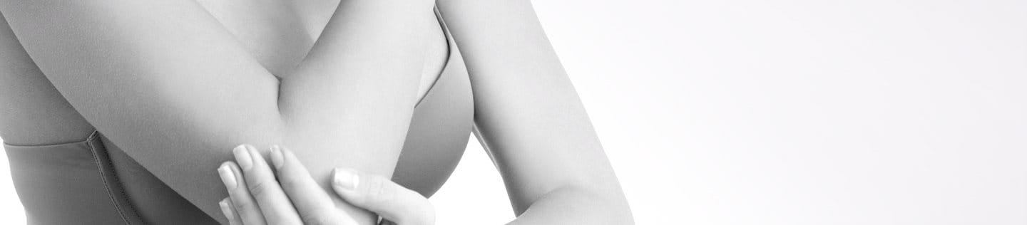 Kobieta w biustonoszu dotykająca łokcia