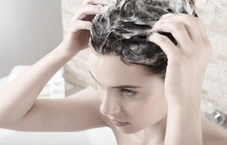 žena šamponira kosu Eucerin šamponom