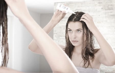 Woman applying scalp treatment