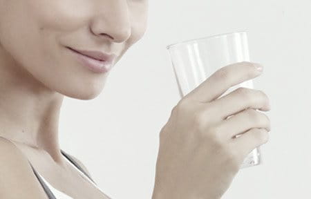 Woman is holding a glass of water.
