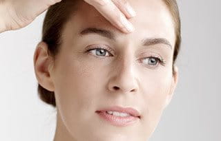 Woman applies concentrate on her forehead