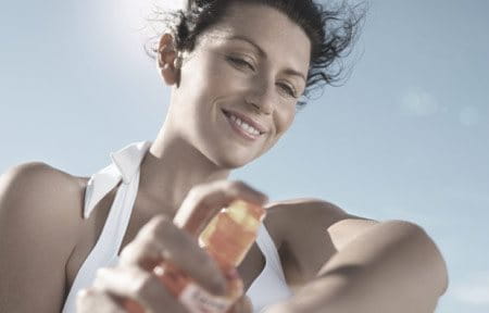 Woman applying sunscreen on her arm.