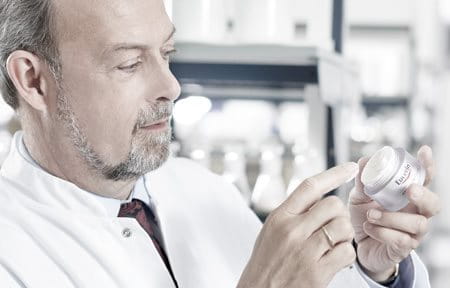 Male scientist holding Eucerin cream pot