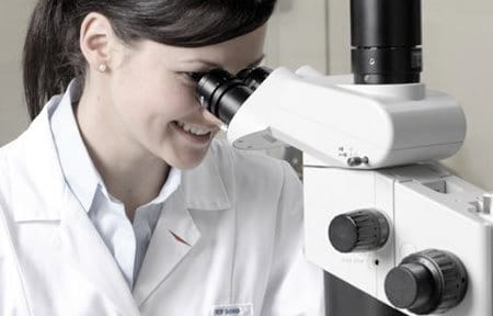 Female scientist looking through miscroscope