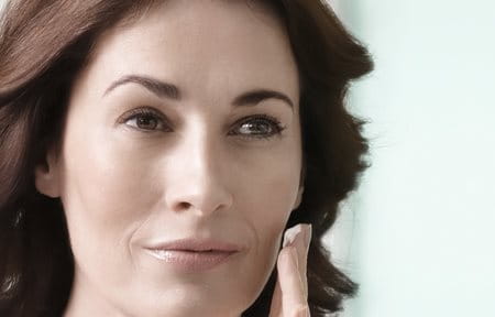 Woman applies Eucerin Volume-Filler Night Care on her face 