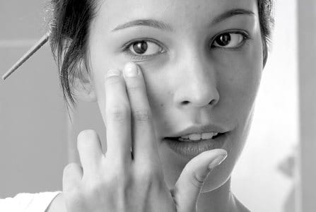 Woman applying acne treatment on face