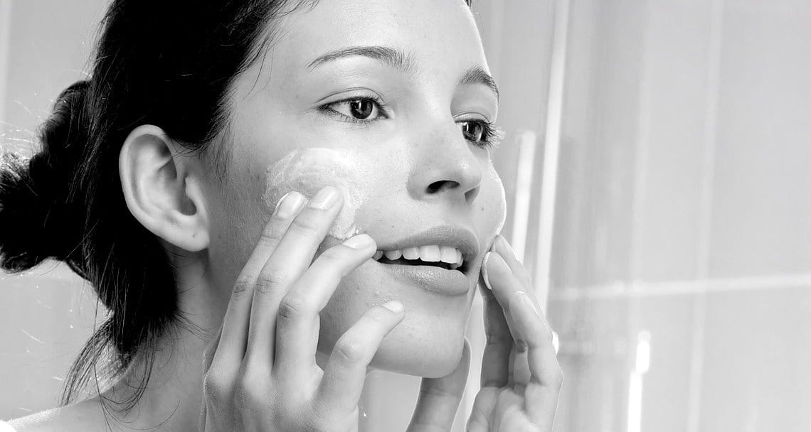 Woman appliying cream on her face
