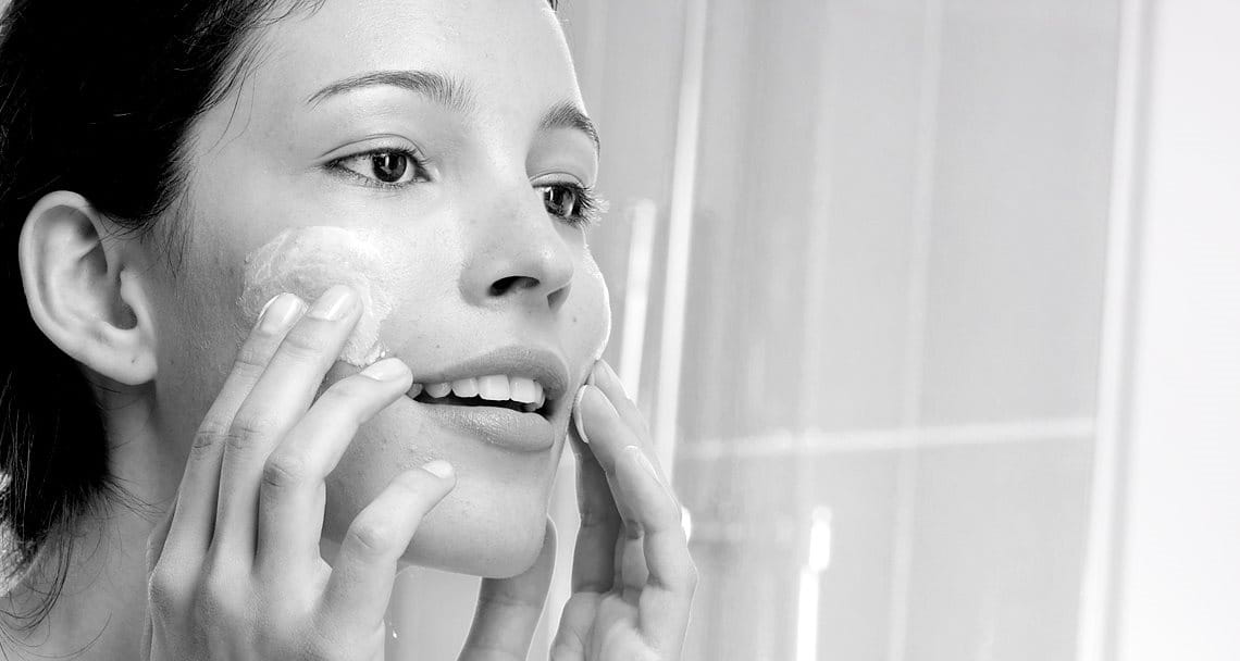 Woman appliying cream on her face
