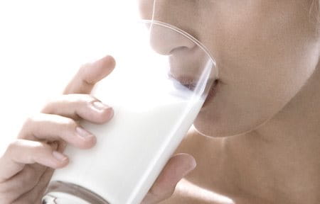mulher a beber um copo com leite