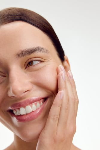 Woman laughing touching her face