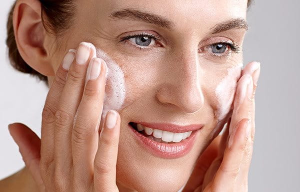 Woman using lotion on her face