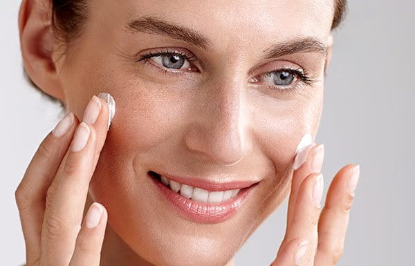 Woman using creme on her face