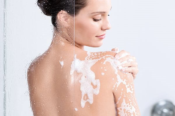 Woman applying exfoliant in shower