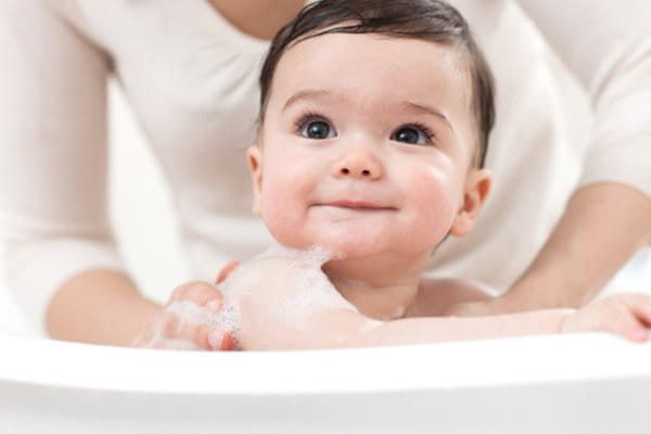 Baby being bathed by their mother