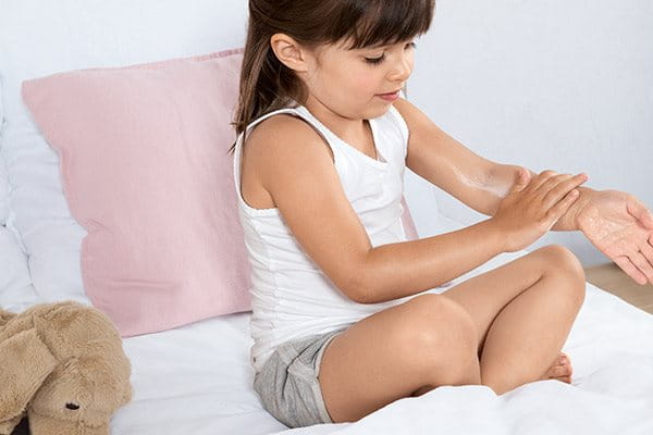 Young girl applying Eucerin Acute Care Cream