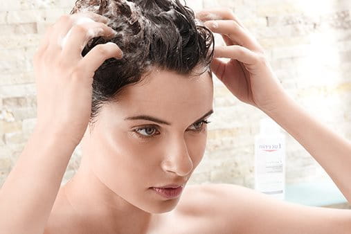 žena pere kosu Eucerin DermoCapillaire šamponom