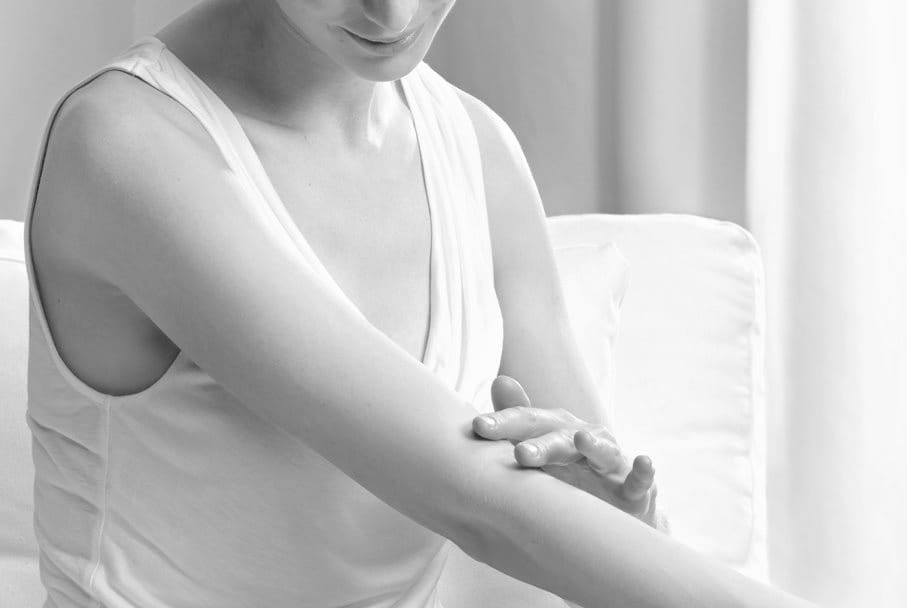 Woman touching the crook of her arm.