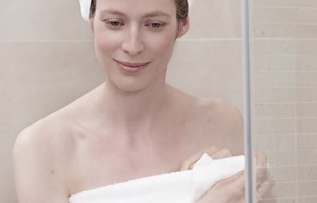 Woman after shower, wrapped in a towel, towel turban on her head.