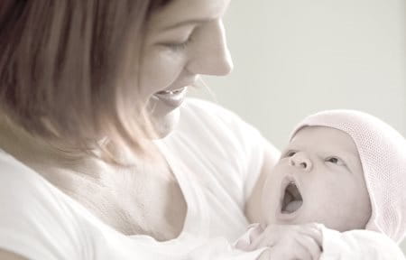 mulher com bebé recem nascido ao colo