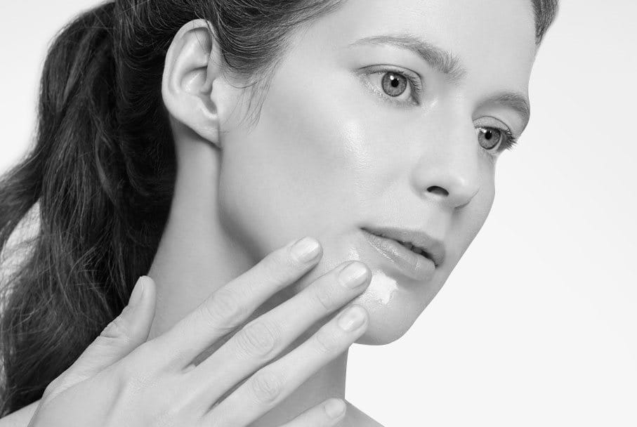 Woman touching her face with hand.