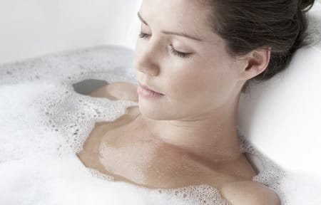 Woman relaxing in a foamy bath