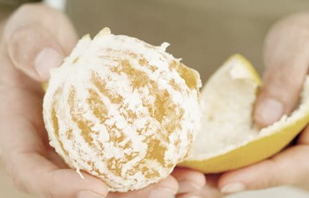 Hands peeling an orange