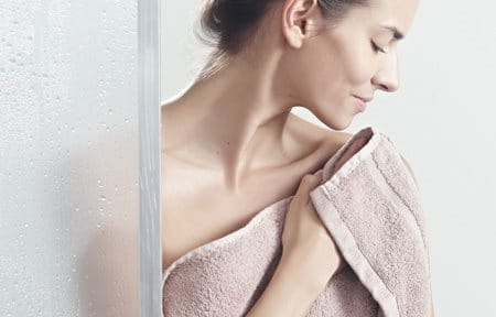 Woman pats her skin after showering