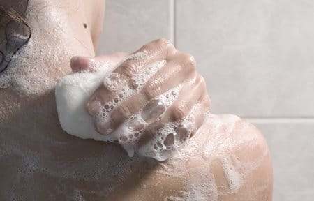 osoba u tušu sa sapunom u ruci